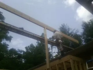 Carpenter setting a ridge beam over a new addition frame — Ice Dam Removal by Roofing Brothers in Guide Rock