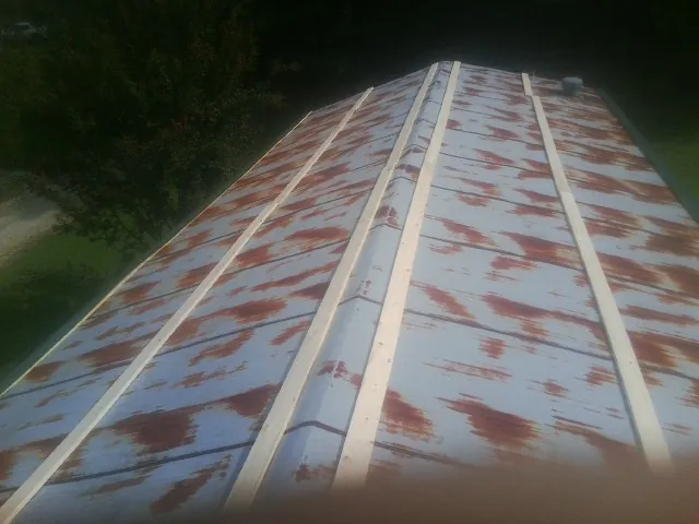 Rusted metal roof panels with new wood purlins before replacement — Storm Damage Roof Repair in Guide Rock by Roofing Brothers