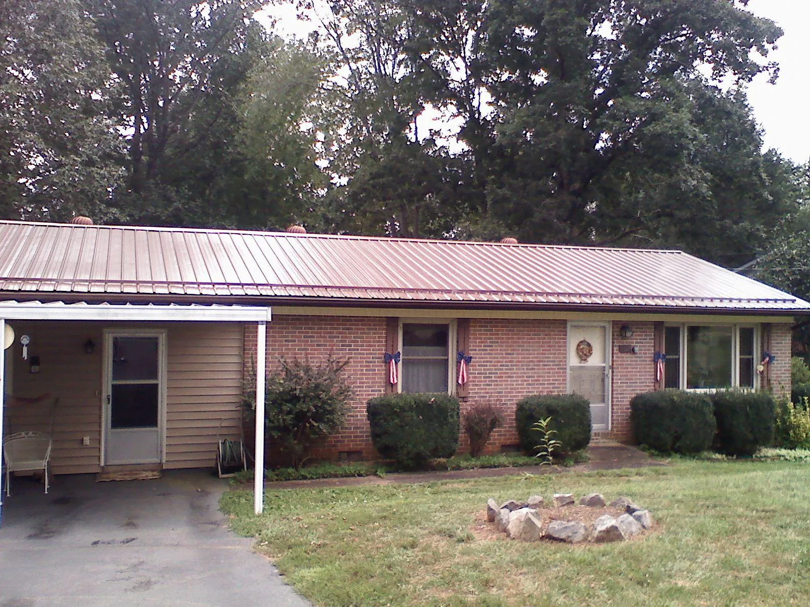Bronze metal roof and carport on a brick ranch home — Roof Repair work by our crew in Guide Rock